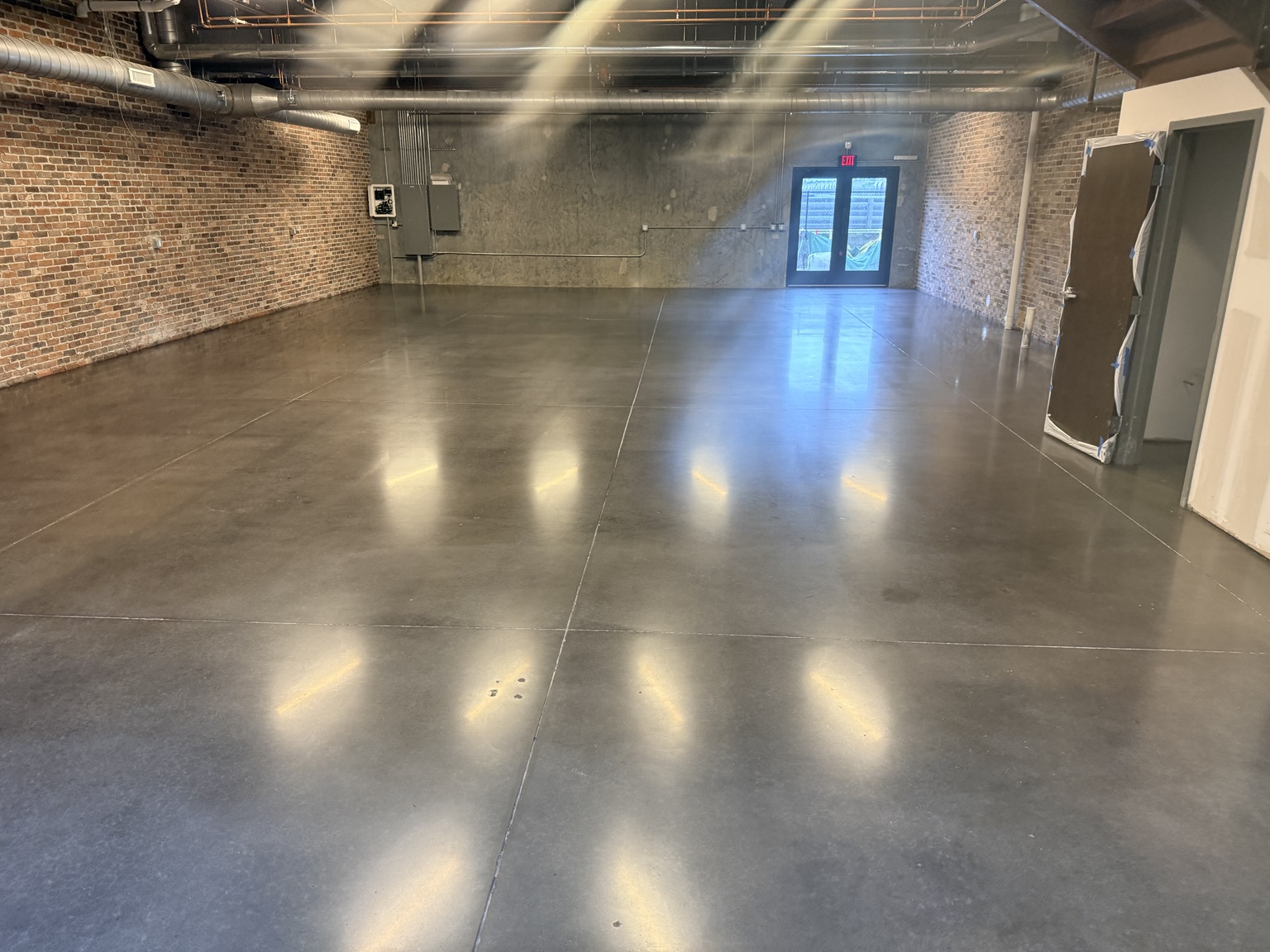 Finished dyed concrete in a brick-walled interior